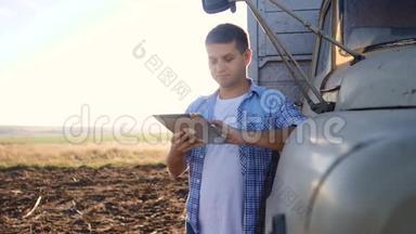 聪明的农业司机。 男子农民司机站在卡车附近的数字平板电脑。 慢动作视频。 肖像